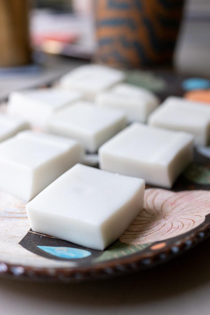Coconut dessert cut into squares on plate