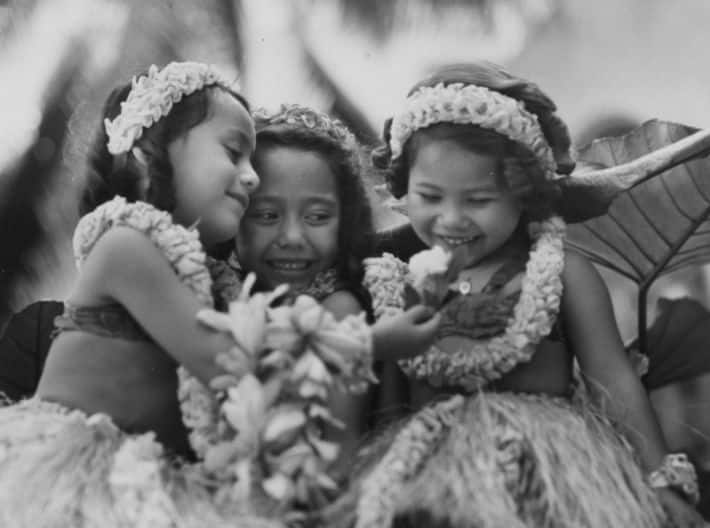 Girls looking at a flower.