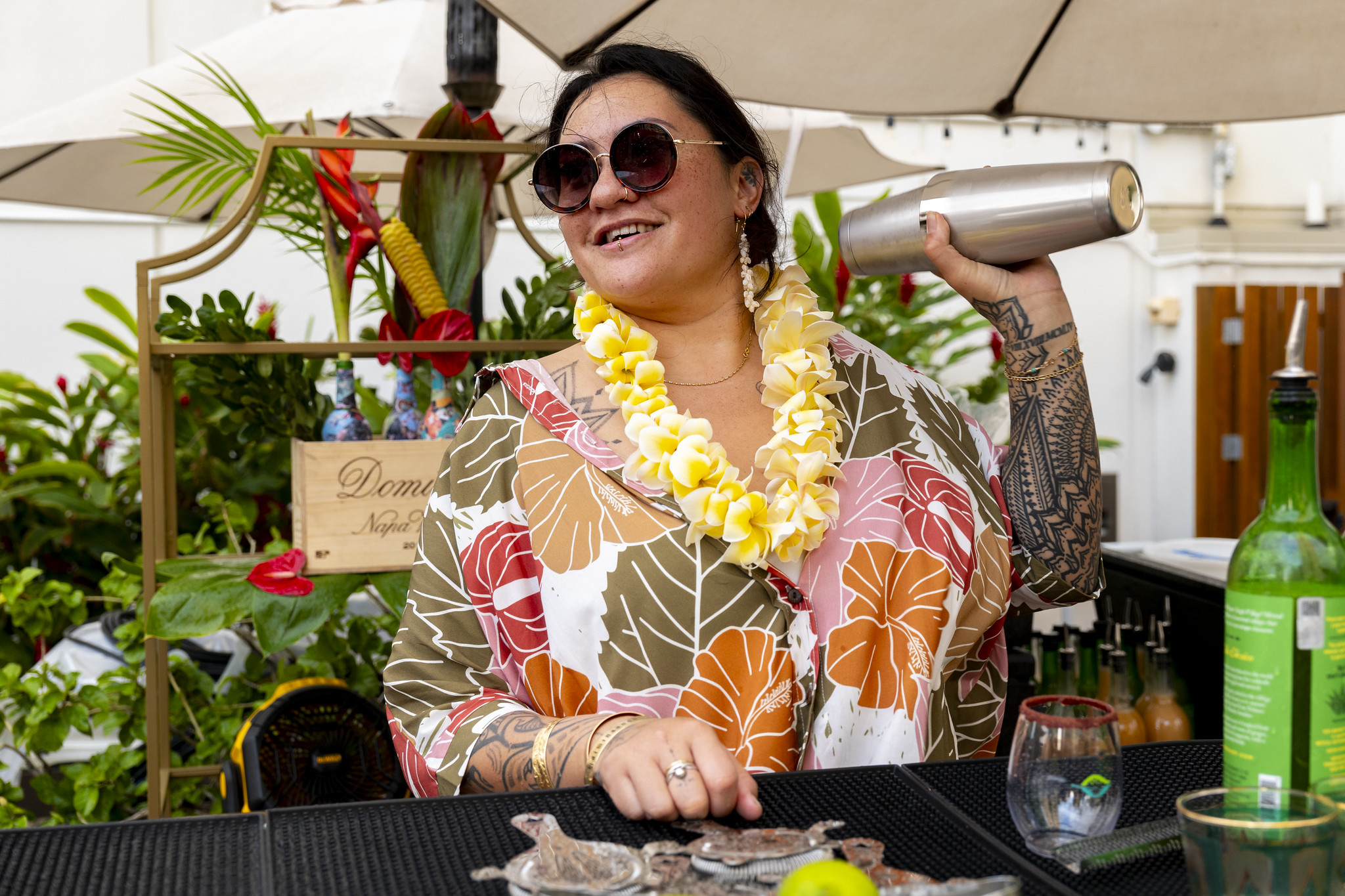 Woman shaking cocktail shaker at event.