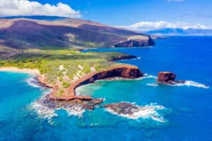 Aerial view of Lanai, Hawaii featuring Hulopo'e Bay and beach, Sweetheart Rock (Pu'u Pehe), Shark's Bay, and the mountains of Maui in the background hateii hawiia hawaii. hawaiii hawiaii hwaii hawaai hawall hawii hawwai hawwaii hawwii hiwaii haiwaii hawia hawwi 1993615100