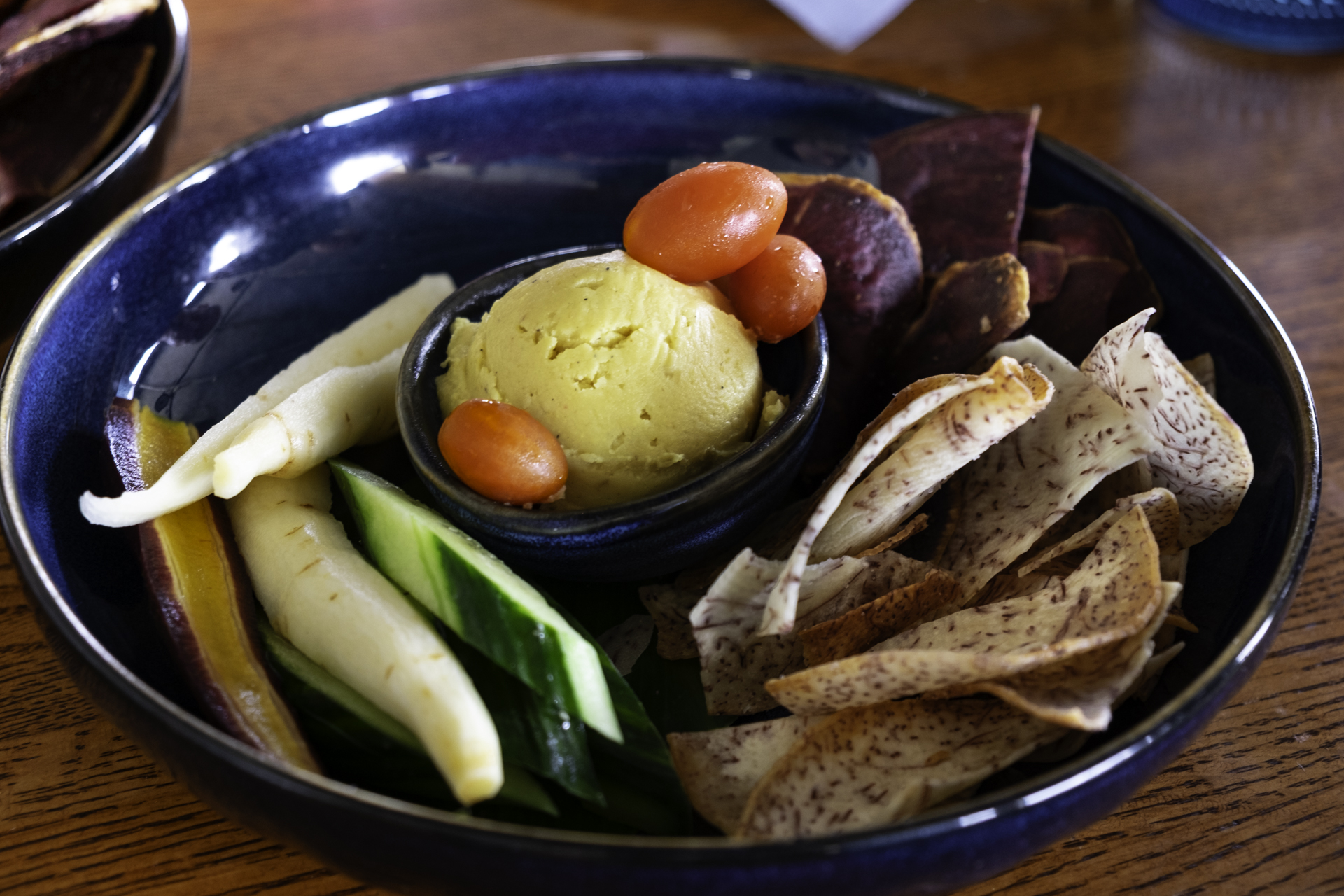 ulu hummus with cherry tomatoes, taro chips, cucumber slices and carrots